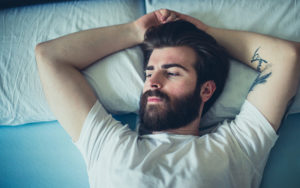 man with beard laying in bed