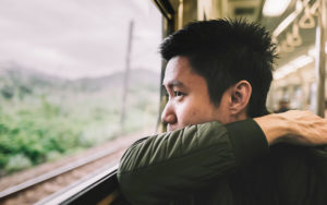 man looking out train window
